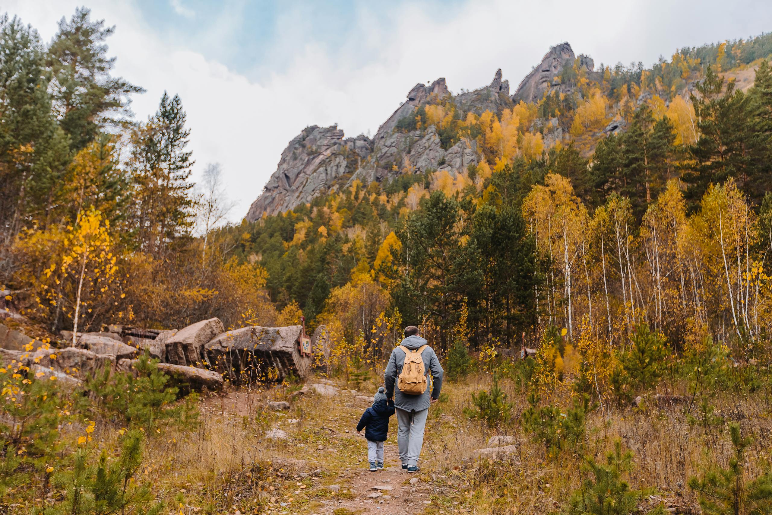 Man and Baby Walking Near Trees