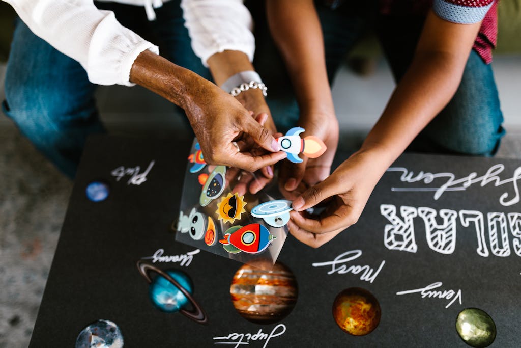 Mother and Daughter Decorating a School Project with Stickers